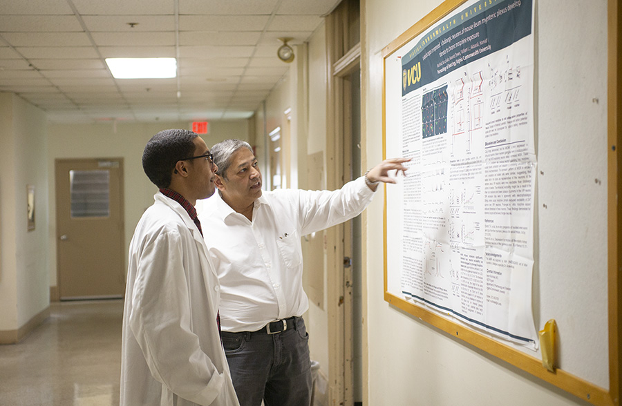 Hamid Ackbarali and Stanley Cheatham looking at a scientific poster
