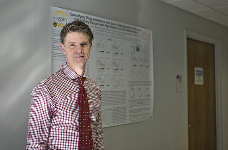 dr jason reed in front of poster